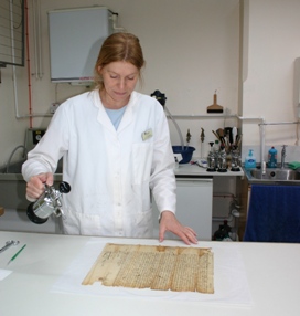 Image of a conservator spraying a document with a mixture of deionized water and IDA (alcohol)