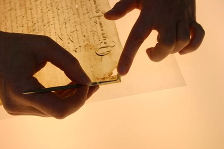 Image of a conservator wet-repairing a document using Japanese paper